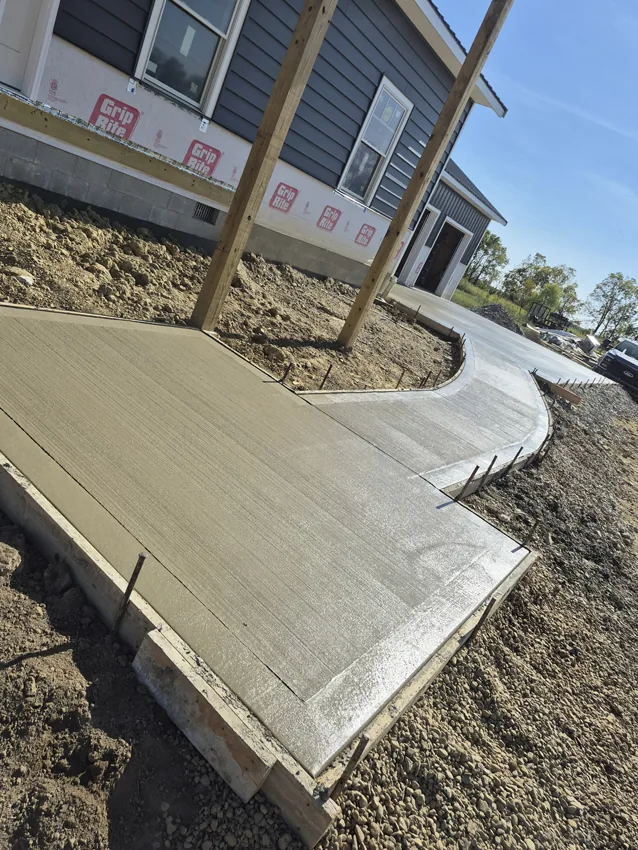 Fresh concrete driveway approach beside a residential garage