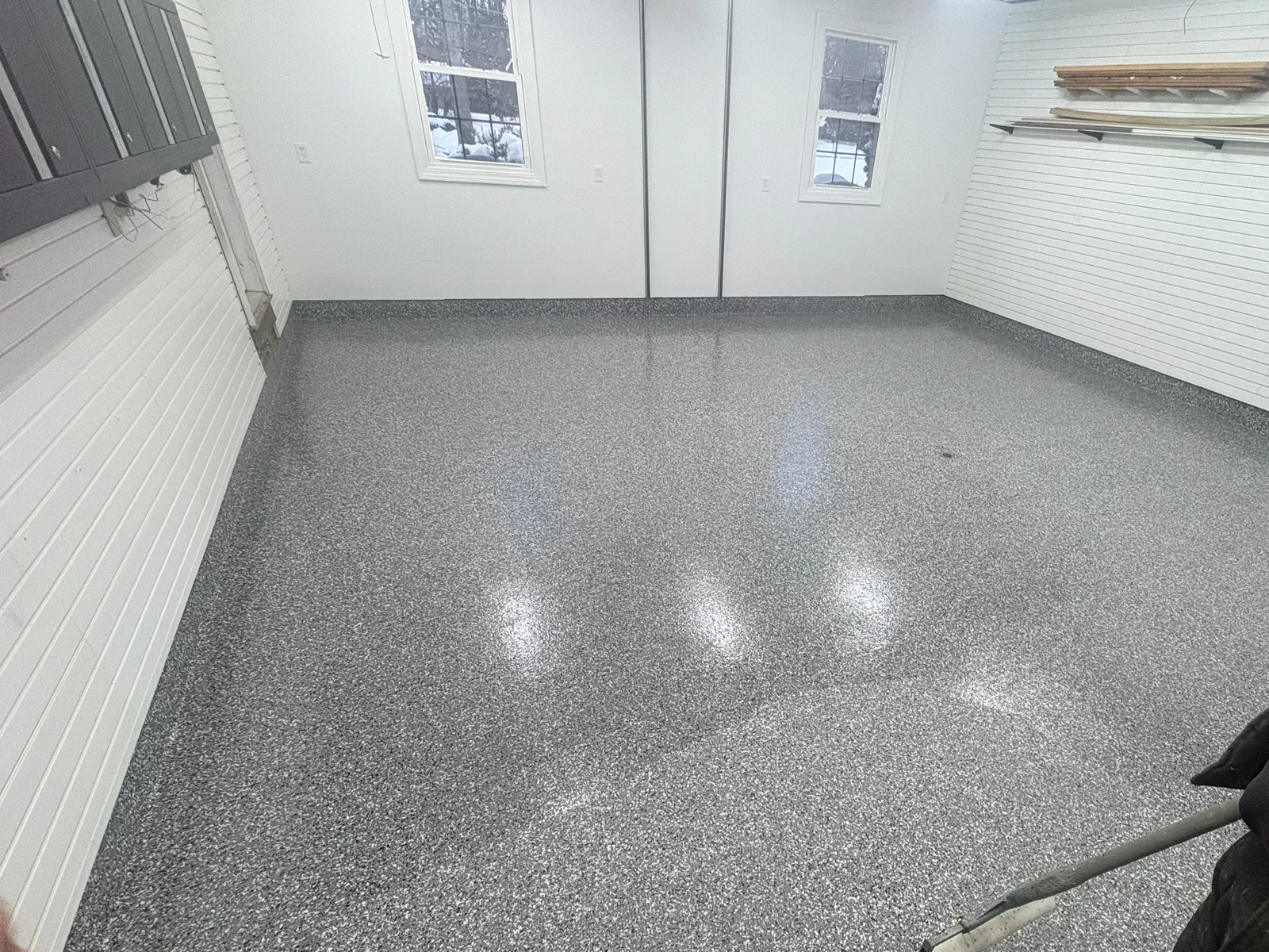 Completed gray decorative flake coating across a residential garage floor