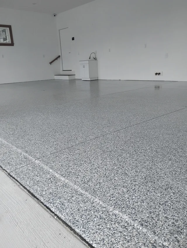Light gray decorative flake floor in a finished residential garage